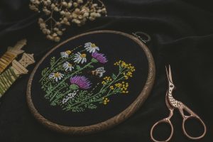 Fabric embroidery project and scissors closeup
