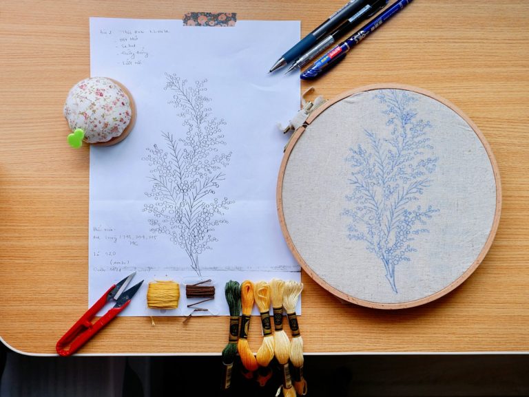 Embroidery hoop with floral design and sewing supplies