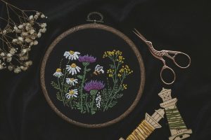Hand embroidered floral project and scissors in natural light